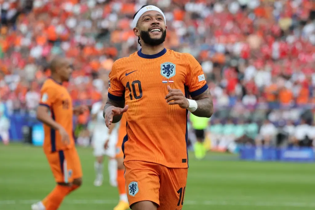O atacante Memphis Depay comemora vestindo a camisa 10 da Holanda; sua presença eleva o nível dos jogadores do Corinthians na seleção e em competições internacionais.